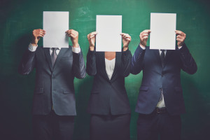 Elegant business partners holding blank papers on green background