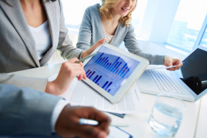 Close-up of businesswoman holding touchpad with document