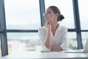 portrait of Young pretty business woman work on notebook computer in the bright modern office indoors