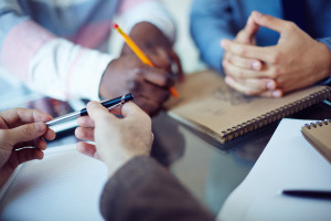 Male hands holding pen in working environment