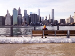 free- man at bench looking at city skyline